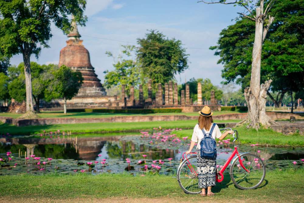 Une touriste visitant un temple à Sukhothai
